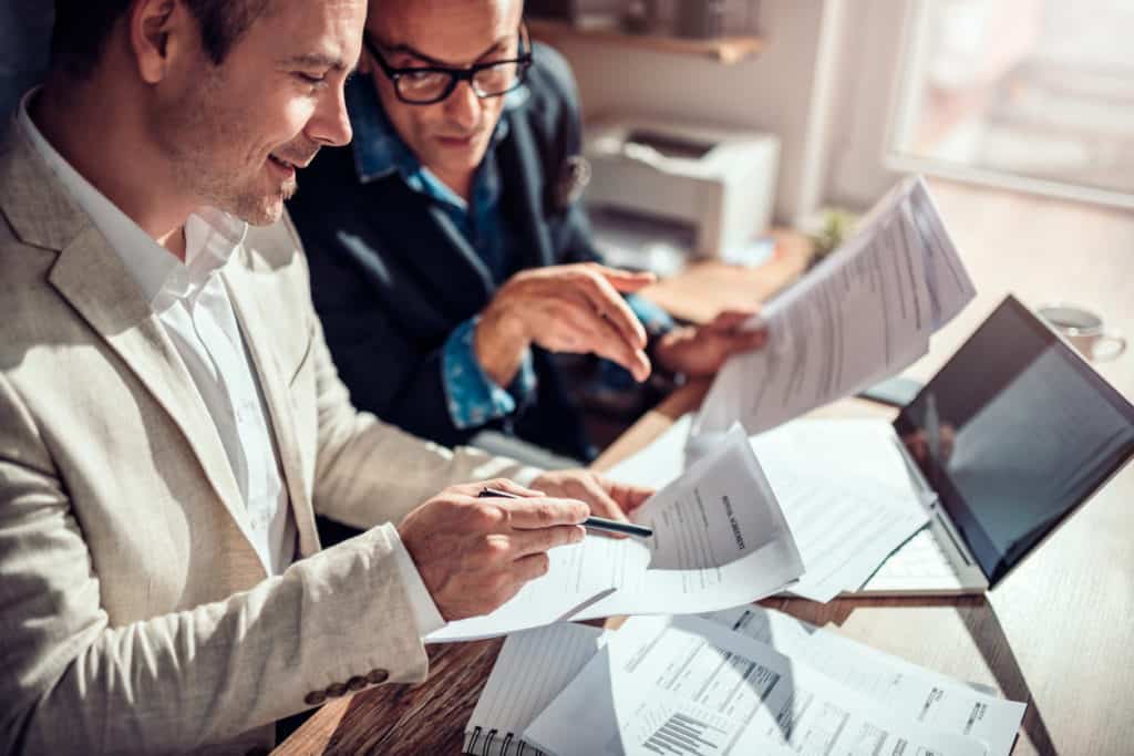 businessmen discussing strategy with papers and charts.jpg