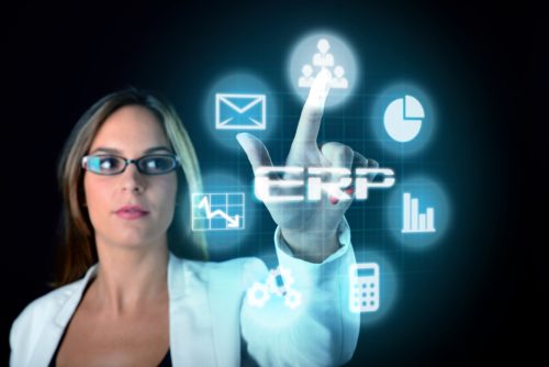 A woman wearing glasses and a white jacket selects an icon from a floating digital set of ERP icons