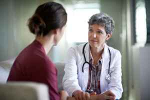 female doctor listens to female patient