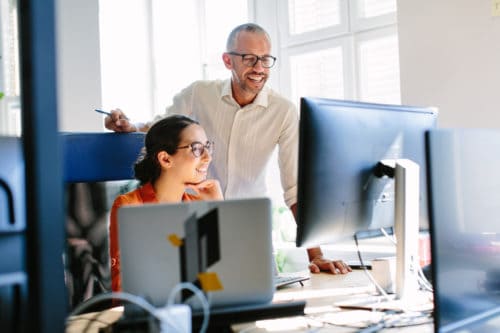 man in woman in front of computer at small business