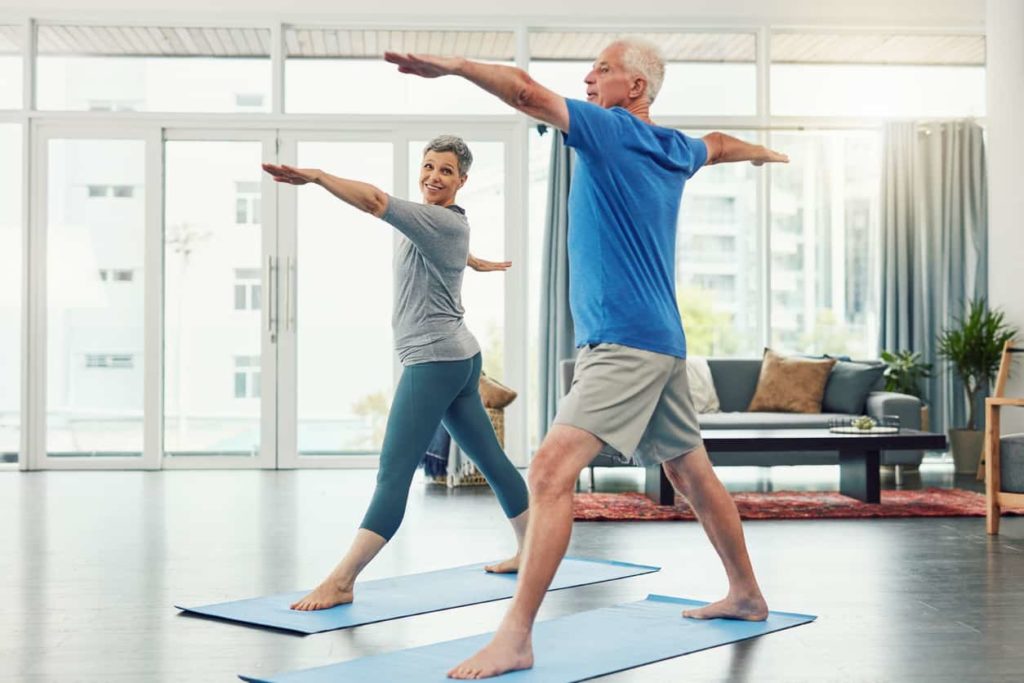 mature couple practicing yoga at home