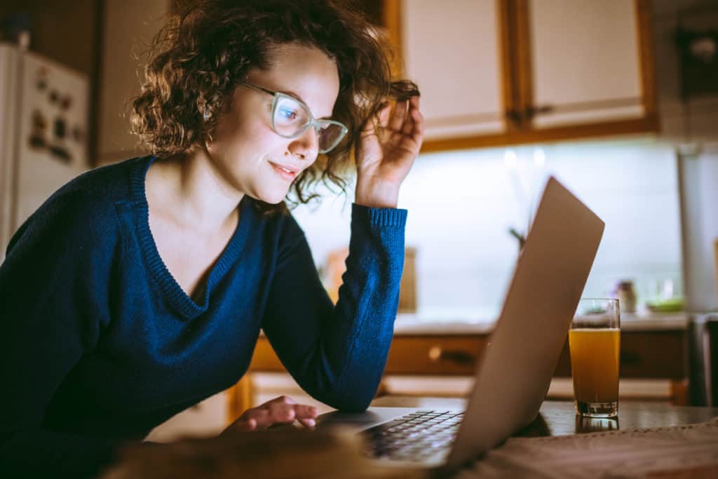 Millennial reviewing a business on a laptop